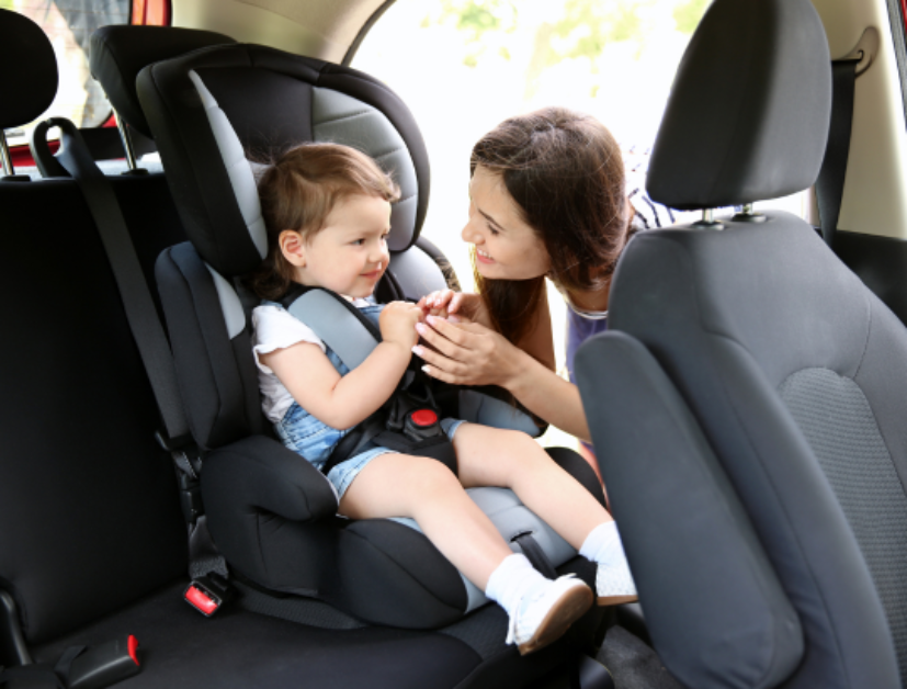 mulher fechando o cinto de segurança da cadeirinhas de auto com sua bebÊ